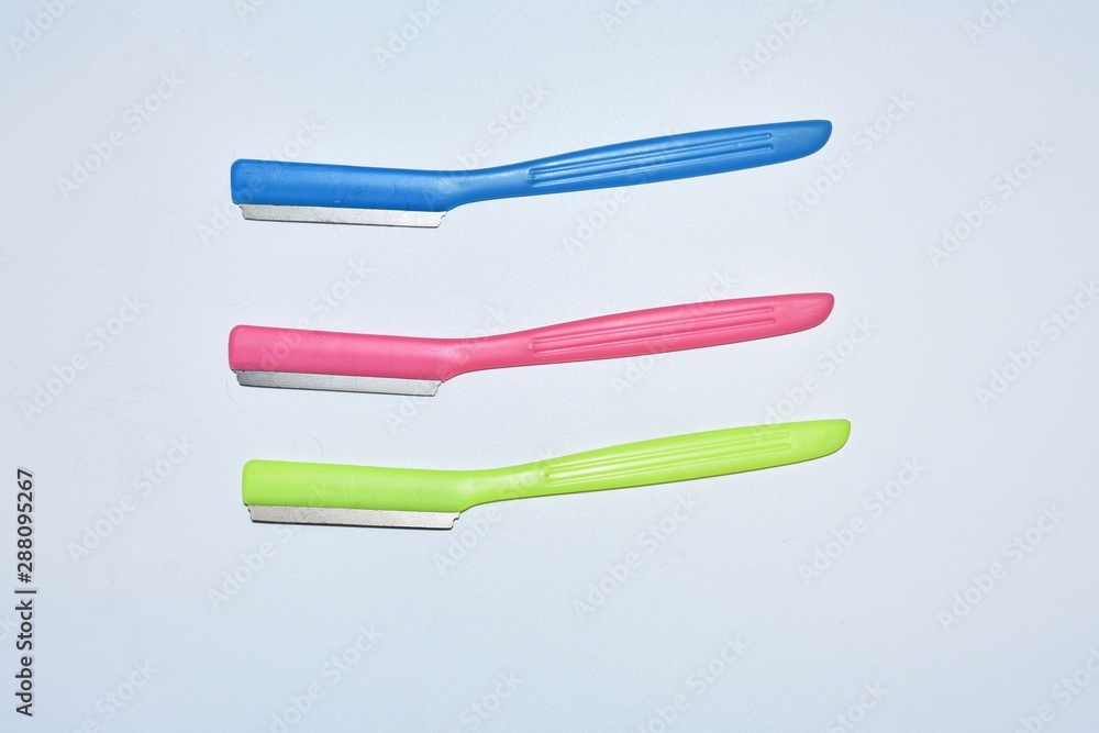 Collection of colorful plastic handle razor used on white background