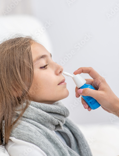 Doctor using nose spray to cure her teen girl at home