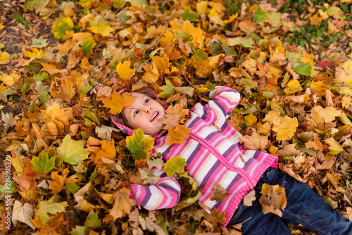 Girl child enjoying autumn season outdoors