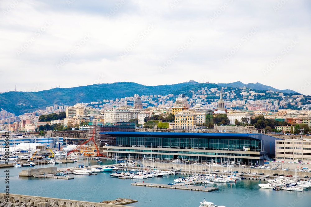 View of Genoa Genova city and port harbor with sea view and yachts, ships. Liguria region of Italy. On cloudy day from high angle