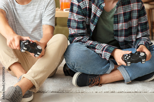 Teenagers playing video game at home