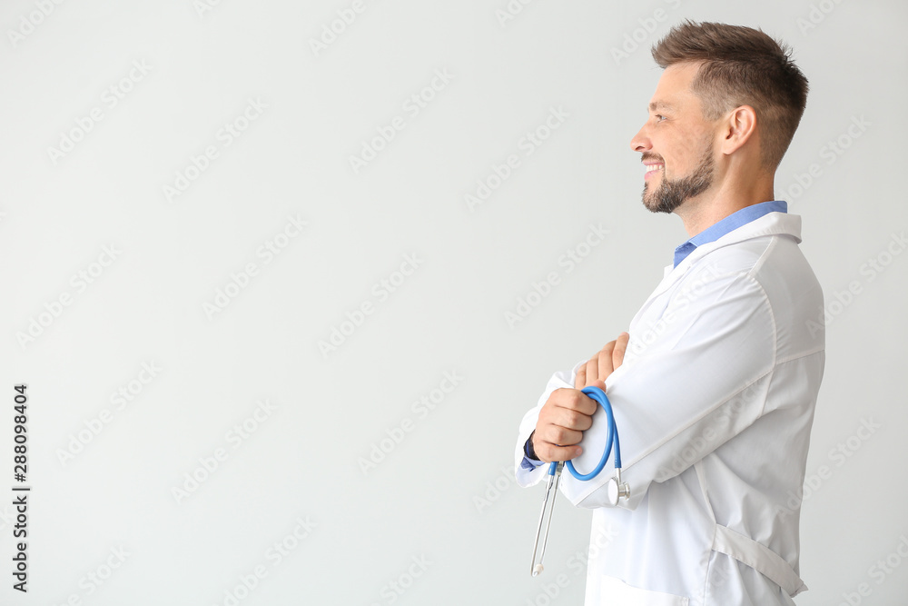 Male doctor with stethoscope on light background Male doctor with stethoscope on light background