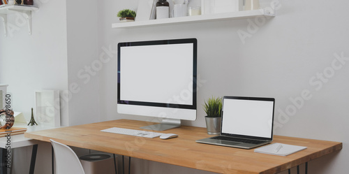 Trendy workplace with desktop computer, laptop computer and office supplies with decorations