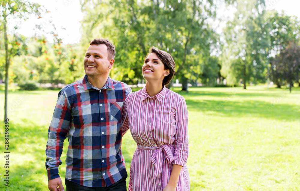 people and relationships concept - happy couple in summer park people and relationships concept - happy couple in summer park