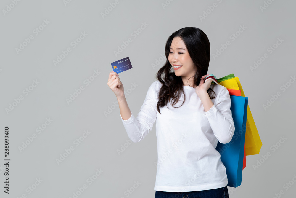 Woman showing credit card and carrying shopping bags Woman showing credit card and carrying shopping bags