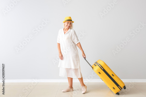 Mature woman with suitcase ...