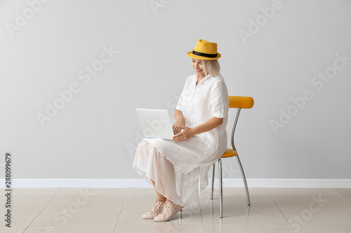 Mature woman with laptop si...