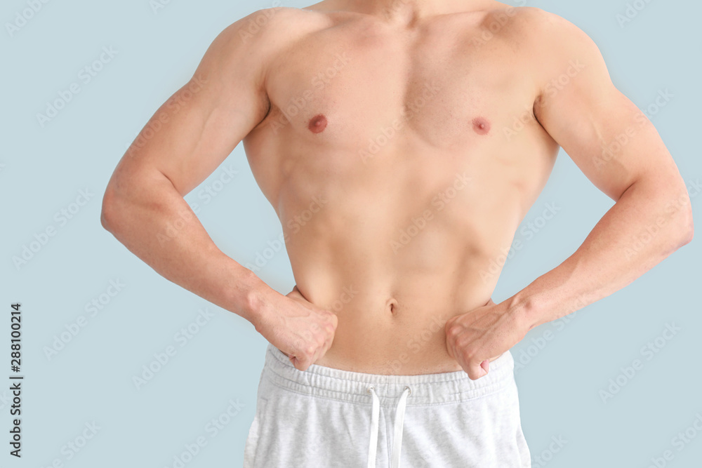Handsome muscular man on color background. Weight loss concept Handsome muscular man on color background. Weight loss concept
