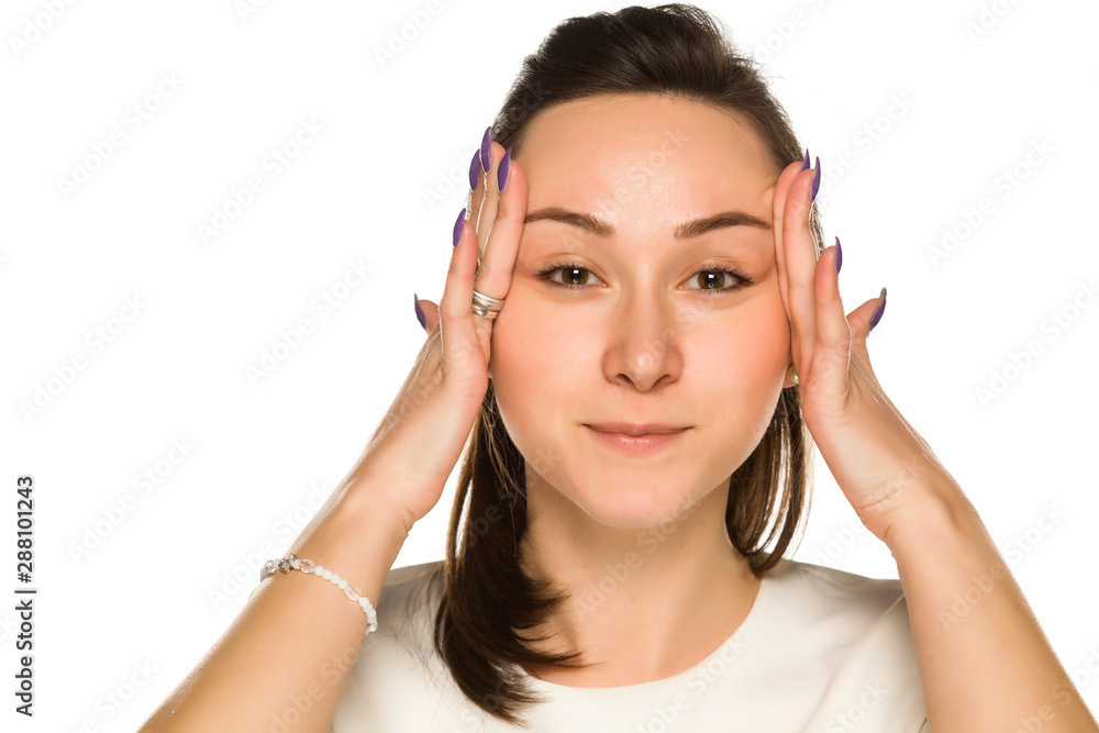 A woman tightening her face on white background A woman tightening her face on white background