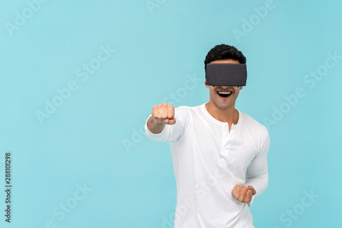 Excited man enjoying watching video from VR glasses