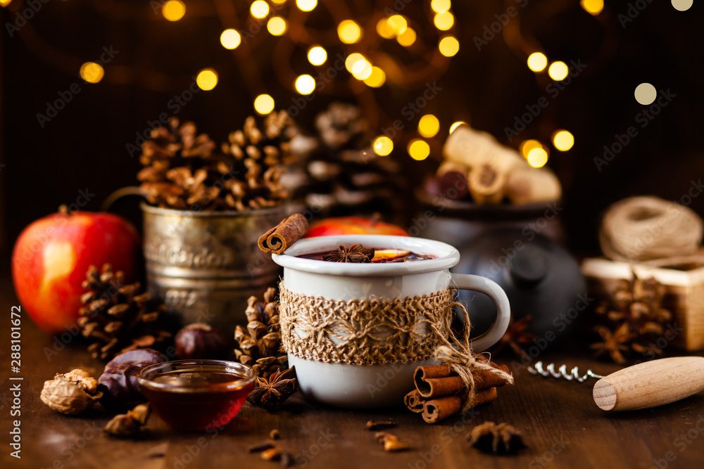 Cozy time at home with a metal mug of hot mulled wine. Autumn, warm clothes, natural ingredients, spice, fruit and honey. Corkscrew to open wine. Rustic decor, festive mood Cozy time at home with a metal mug of hot mulled wine. Autumn, warm clothes, natural ingredients, spice, fruit and honey. Corkscrew to open wine. Rustic decor, festive mood