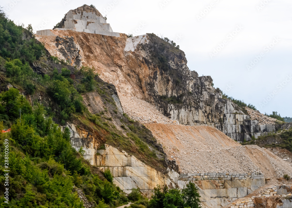 Marble extraction at the famous Carrara white marble quarries. Image clearly shows how much mountain has been removed. Apuan Alps, Italy.