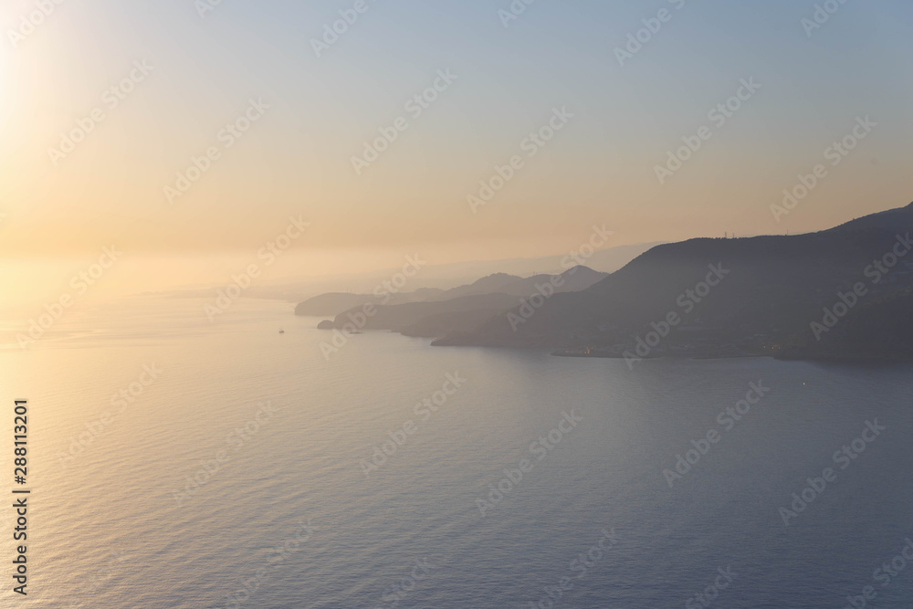 Scenic sunset over the mountainous coast of the Mediterranean sea.