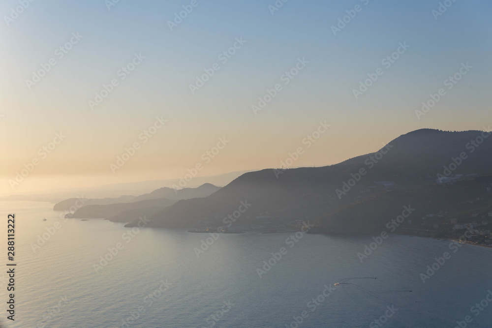 Scenic sunset over the mountainous coast of the Mediterranean sea.