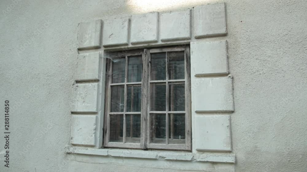 old wooden window, on a gray shabby building, around cobwebs and dirt old wooden window, on a gray shabby building, around cobwebs and dirt