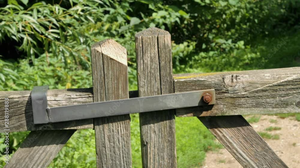 Man closing latch on farm gate Man closing latch on farm gate