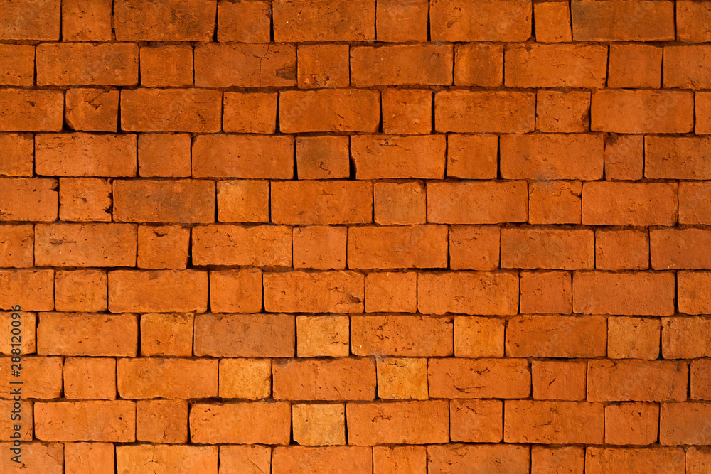 Obraz premium Brick wall, bright red stones from the red sand of Madagascar