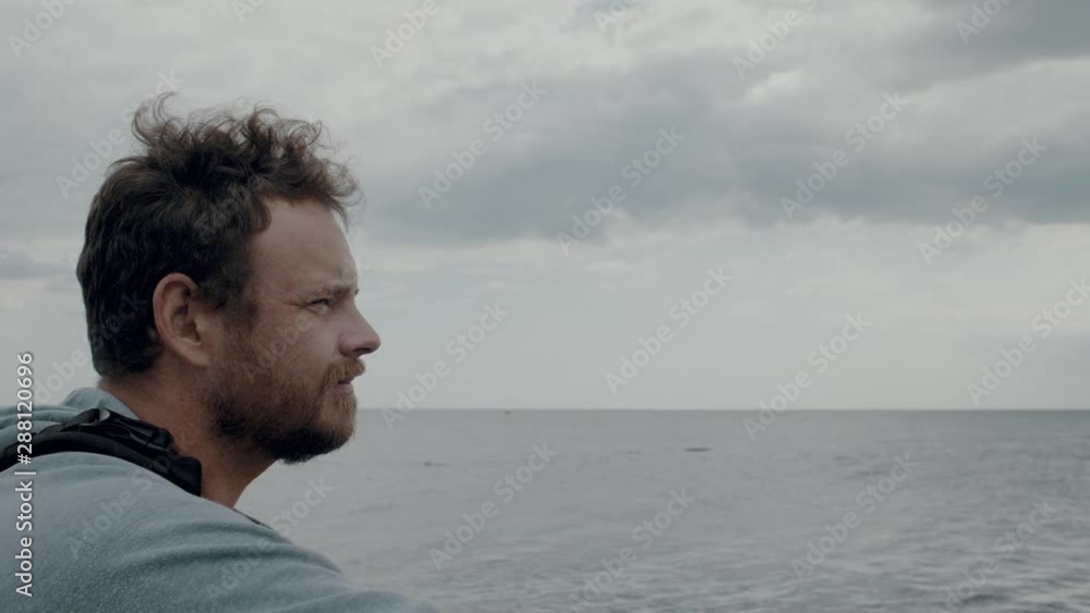portrait of a man with a beard against the background of the sea and clouds, taking a photo of the sea with a camera. 4k. 4k video. 60 fps portrait of a man with a beard against the background of the sea and clouds, taking a photo of the sea with a camera. 4k. 4k video. 60 fps