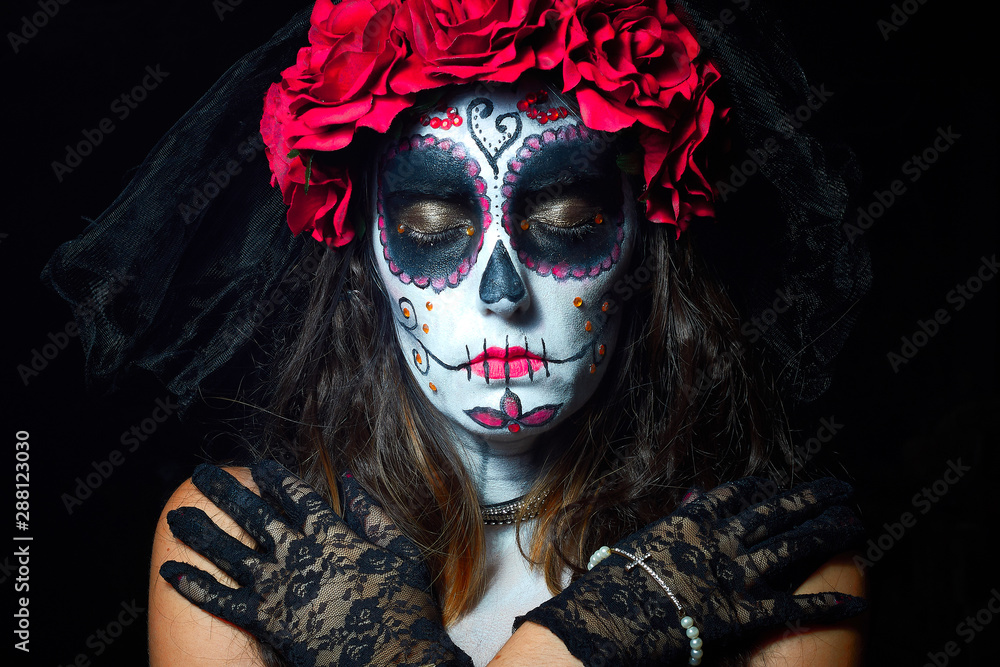 Portrait of woman dressed as catrina, skull to honor the dead in Mexico.