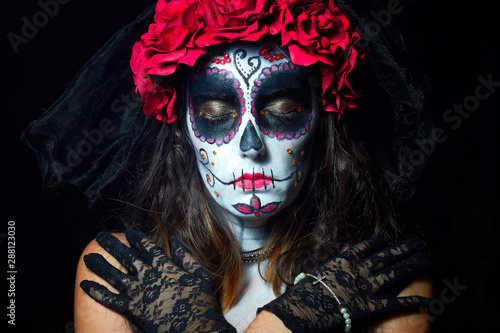 Portrait of woman dressed as catrina, skull to honor the dead in Mexico.