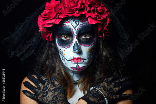 Portrait of woman dressed as catrina, skull to honor the dead in Mexico.