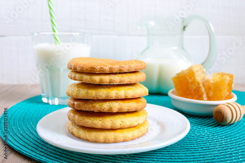 Shortbread dairy cookies with milk and honey. A stack of cookies on a plate.