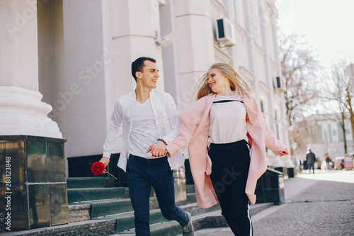 beautiful and stylish blonde along with her handsome guy standing near building in the summer city