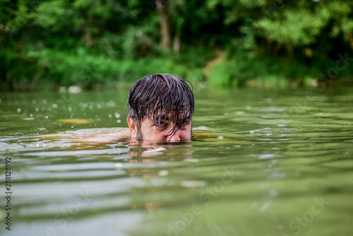 Deep dangerous water. Relaxation and rest. Swimming sport. Swimming skills. Refreshing feeling. Man enjoy swimming in river or lake. Submerge into water. Freshness of wild nature. Summer vacation