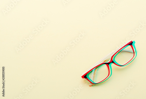 Fashionable accessory glasses on yellow background. Glitch style effect. Vibrant duotone yellow, violet colors. Top view.