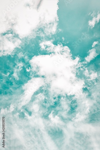 Beautiful white soft fluffy clouds on a cold green sky background