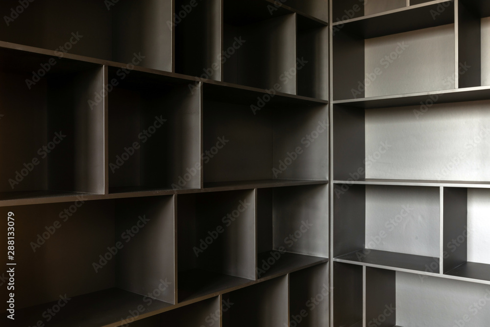 Variously shaped empty shelves of wooden cabinet ready for content in corner Variously shaped empty shelves of wooden cabinet ready for content in corner