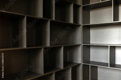 Variously shaped empty shelves of wooden cabinet ready for content in corner