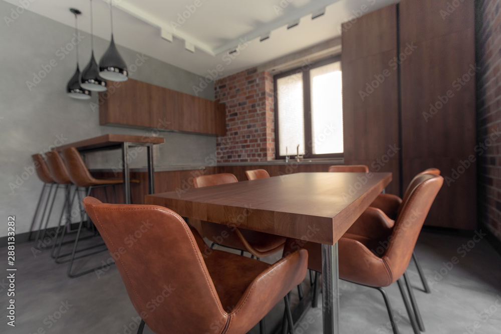 Interior of kitchen with dining table with cozy chairs next to cupboard and counter Interior of kitchen with dining table with cozy chairs next to cupboard and counter