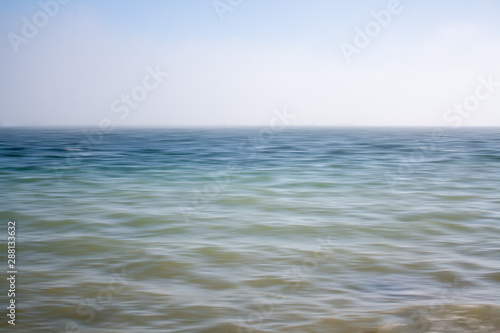 An abstract seascape with blurred panning motion with mussel rafts at the back