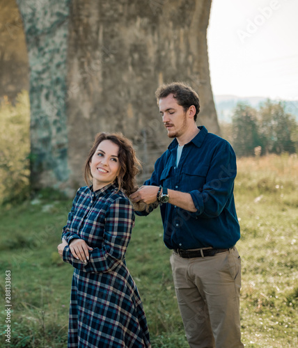 Man and woman in the mountains. Young couple in love in mountains at sunset. Portrait of a happy couple smile to each other . Lifestyle concept. Banner © trofalena