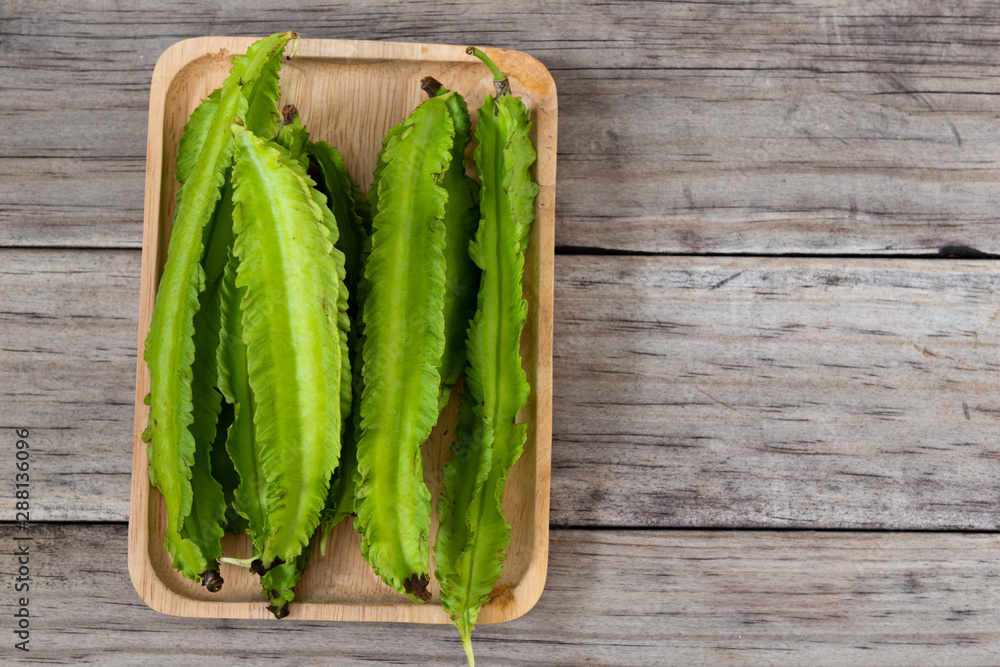 Psophocarpus tetragonolobus, Winged Bean on wood table Psophocarpus tetragonolobus, Winged Bean on wood table