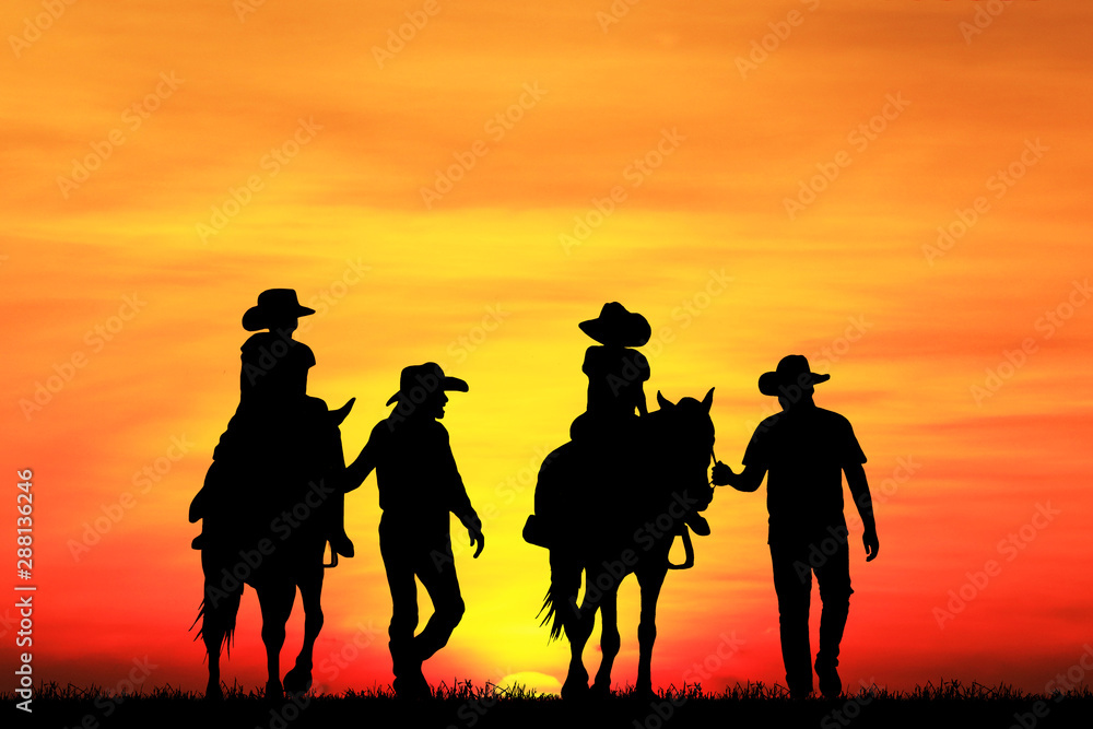 silhouette cowboy and horse on blurry colorful sunset sky.