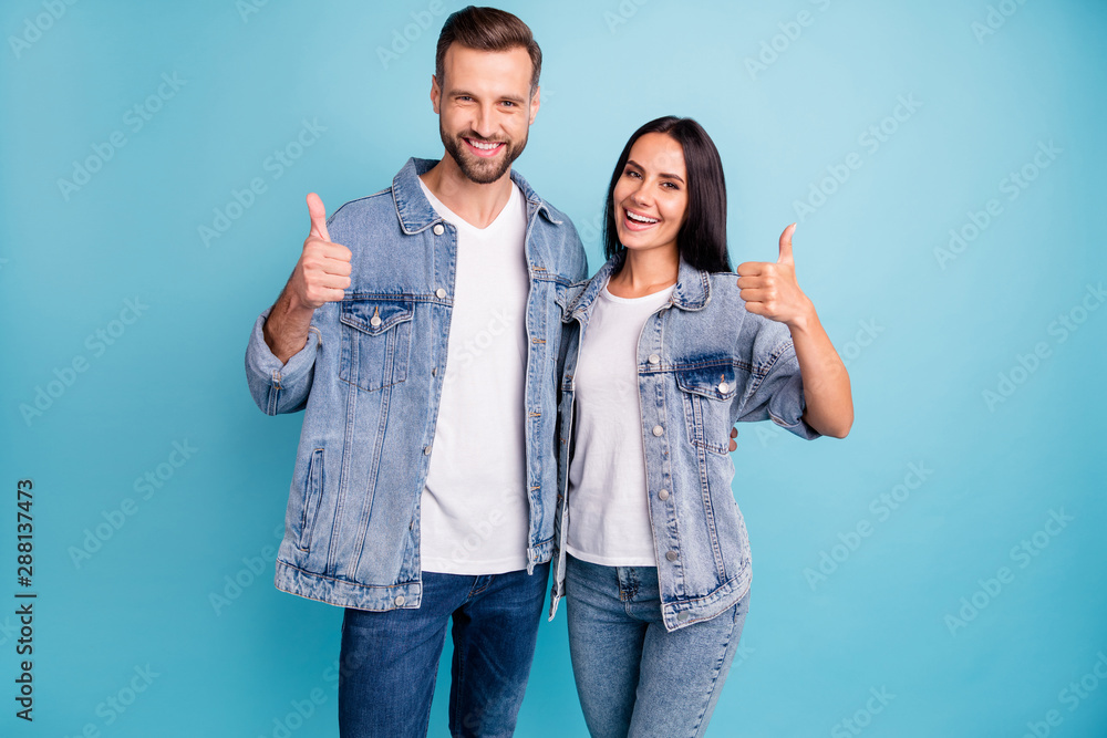 Fototapeta premium Portrait of pretty sweethearts hugging embracing smiling wearing denim jeans isolated over blue background