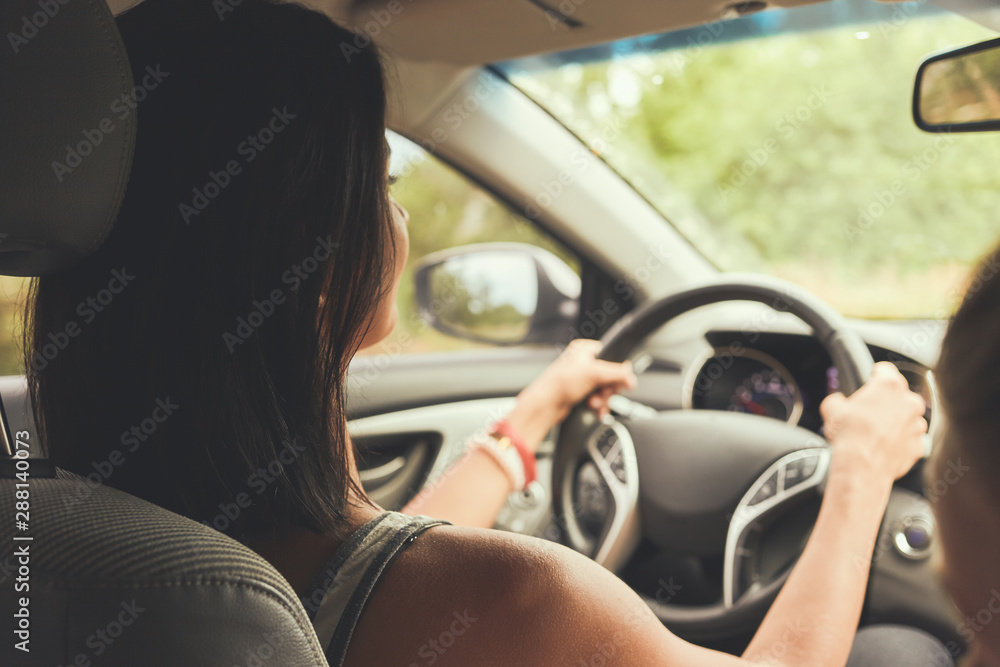 Woman driving a car. Rear view.