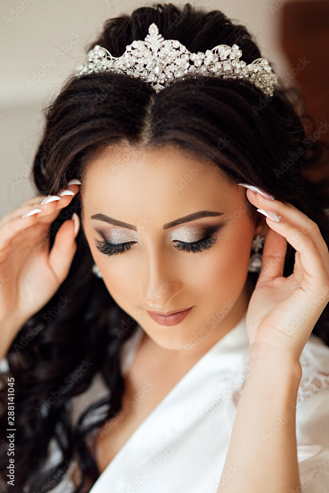 Beautiful bride portrait wedding makeup and hairstyle, girl in diamonds tiara, jewelry model, fashion bride gorgeous beauty. Close up portrait of Beautiful bride lowered her eyes down, shows makeup. Beautiful bride portrait wedding makeup and hairstyle, girl in diamonds tiara, jewelry model, fashion bride gorgeous beauty. Close up portrait of Beautiful bride lowered her eyes down, shows makeup.