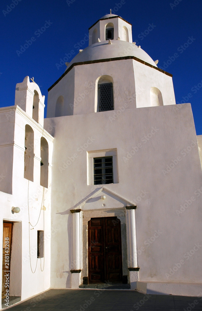 Daytime view of a pretty white church in Fira, Santorini, Greece. Santorini has many churches. The white church is against a blue sky. A white church in Fira, Santorini. White with blue sky. Santorini