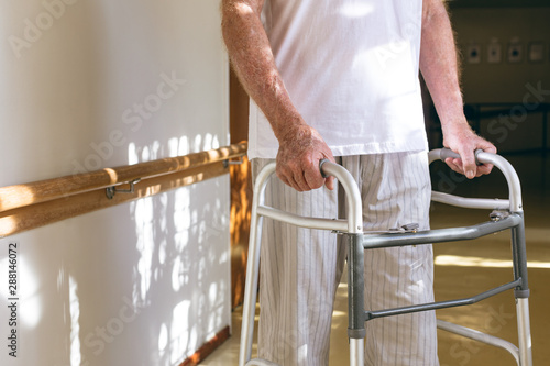 Senior male patient standing with walker