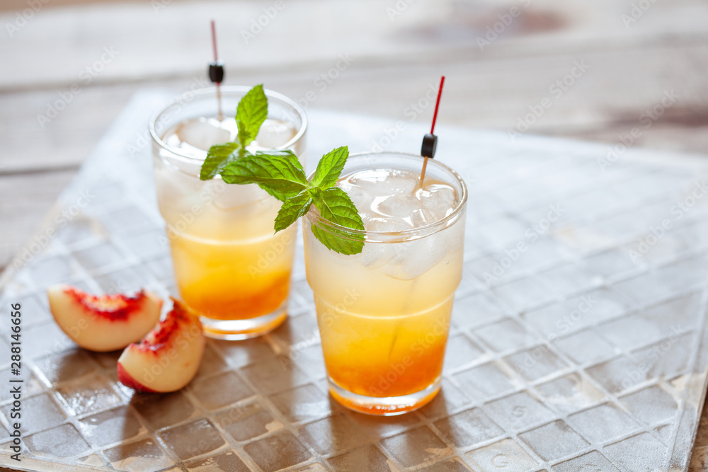 Fototapeta premium Peach cocktail with mint on grey background