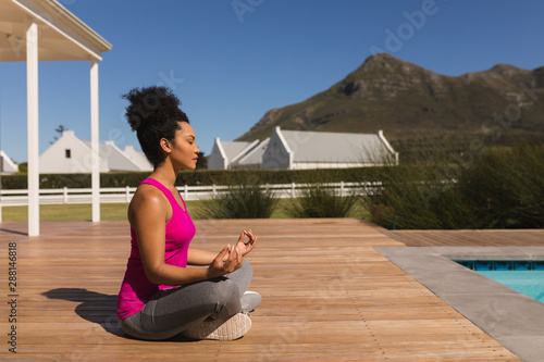 Woman meditating with closed eyes in the backyard of home Fototapeta