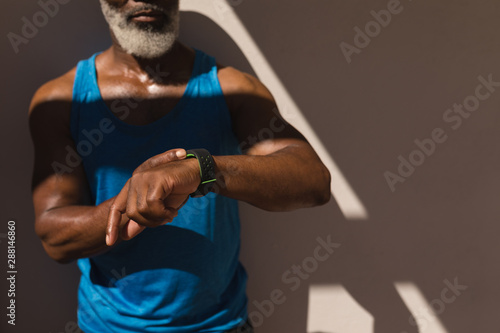 Senior man using smartwatch in the backyard of home © wavebreak3