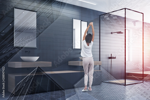 Woman in gray bathroom with shower and sink