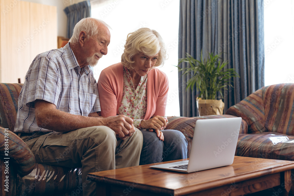 Senior couple making video call on laptop at retirement home Senior couple making video call on laptop at retirement home