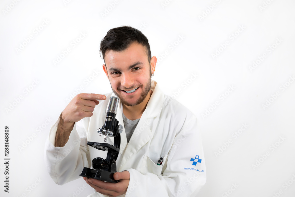Smiling Young male with beard pointing microscope isolated on white background Smiling Young male with beard pointing microscope isolated on white background