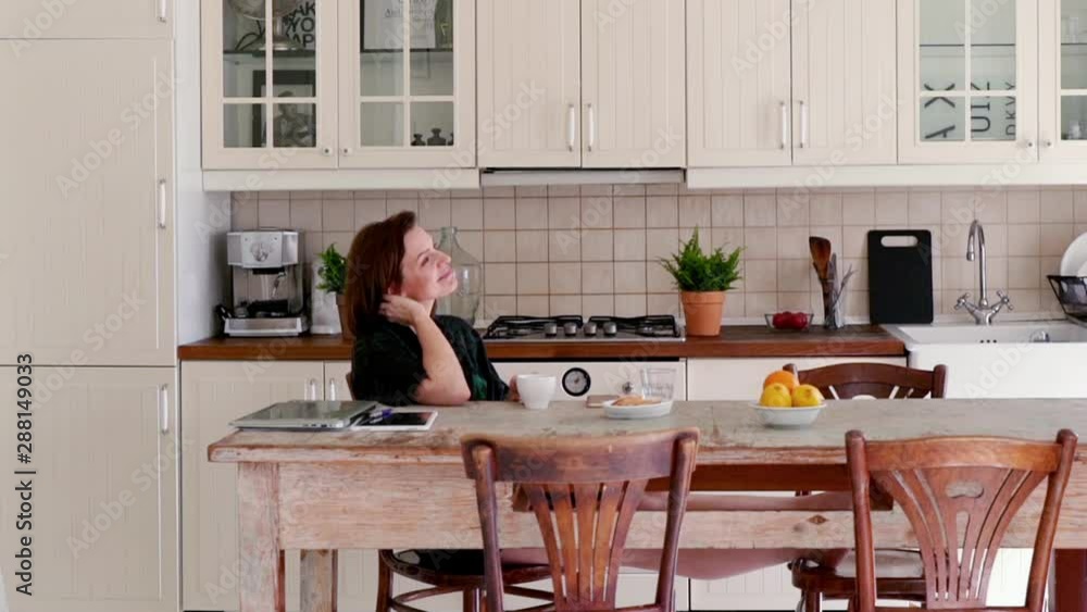 Young, happy woman drinking and relaxing in the kitchen Young, happy woman drinking and relaxing in the kitchen