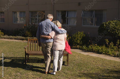 Senior couple standing with arm around in the park